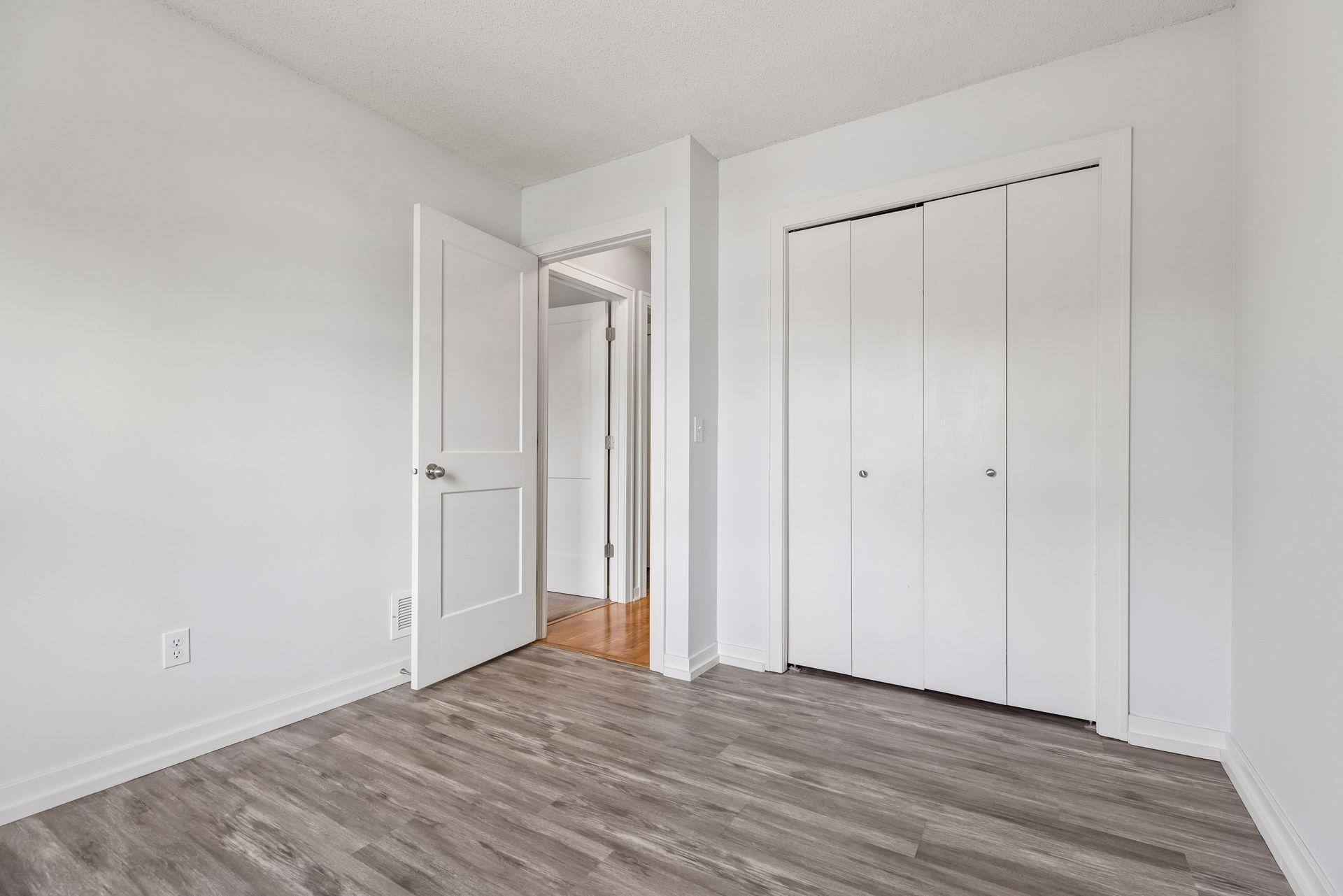 3rd bedroom with luxury wood plank flooring and spacious closet