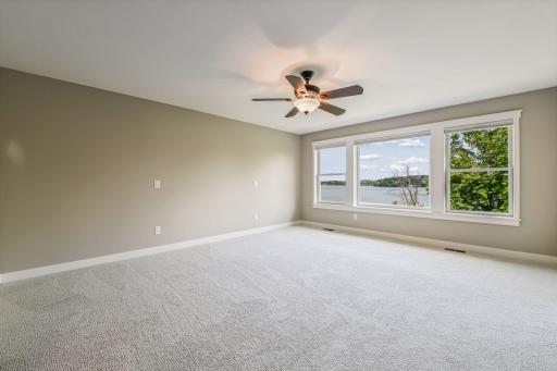 Private and spacious primary bedroom with oversized windows and beautiful views toward Wassermann Lake.