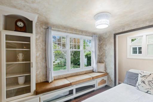 Spacious custom glass-door built-in book case and a charming window seat