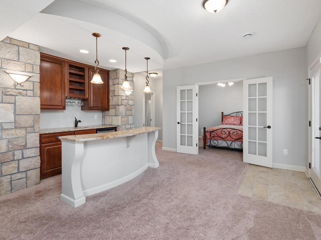 Walkout lower level includes the stylish Wet Bar, while the French doors lead into the fifth Bedroom