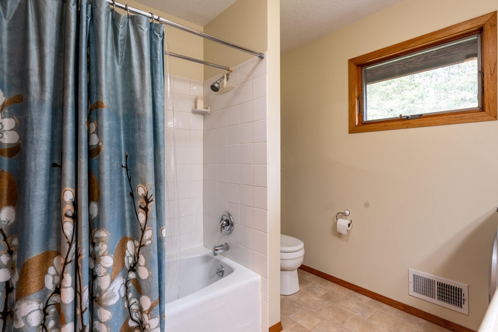 Main level bath has a tub/shower with tile surround.