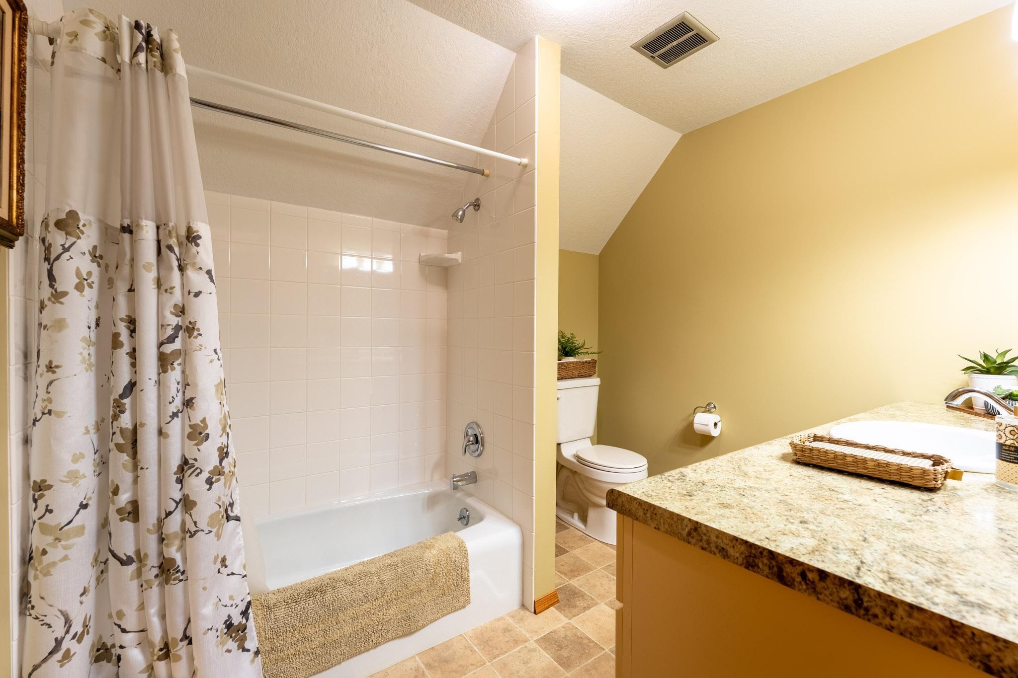 Upstairs full bathroom with tub/shower with tile surround.
