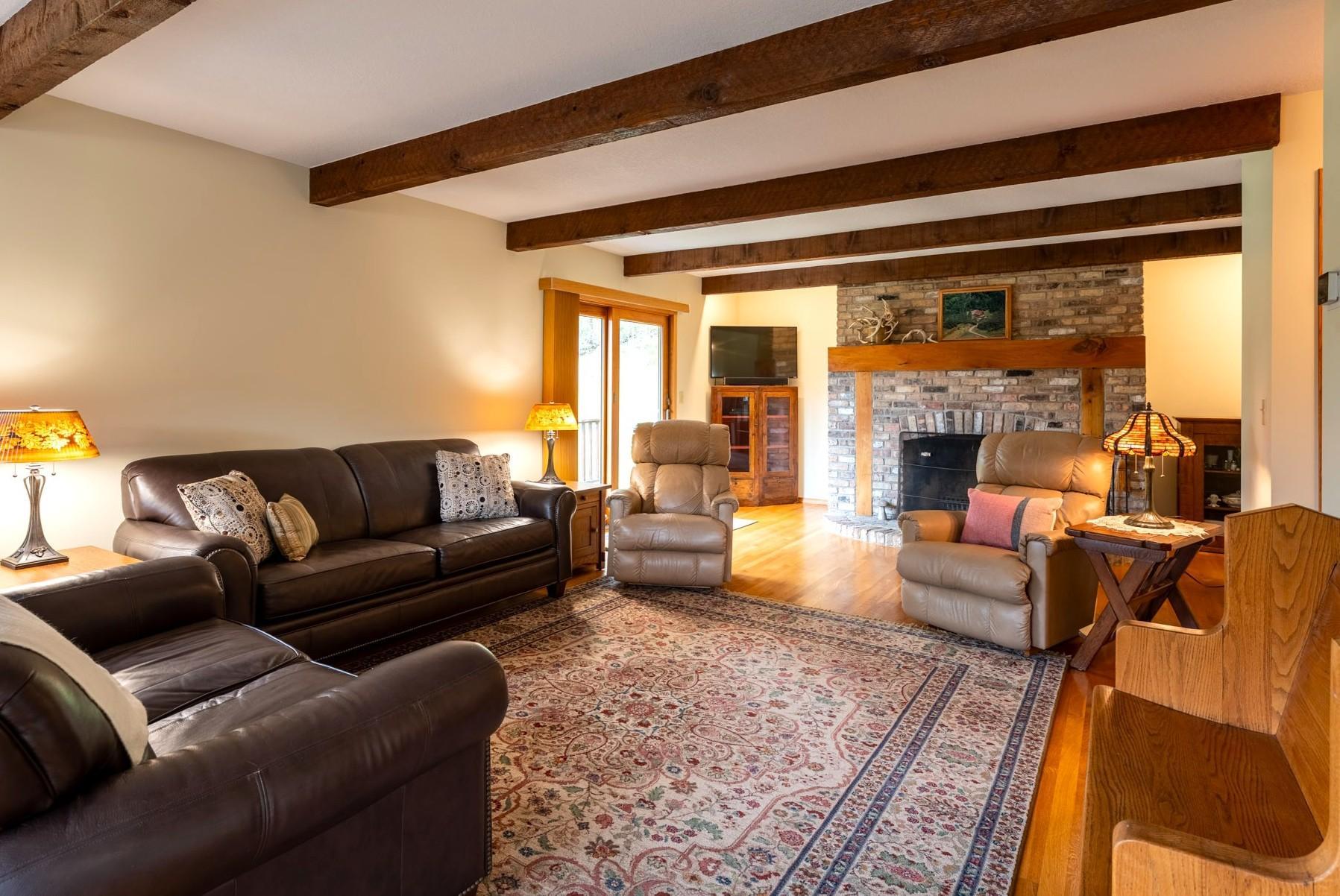 Living Room with brick surround wood burning fireplace and Anderson sliding glass doors out to the wraparound deck.