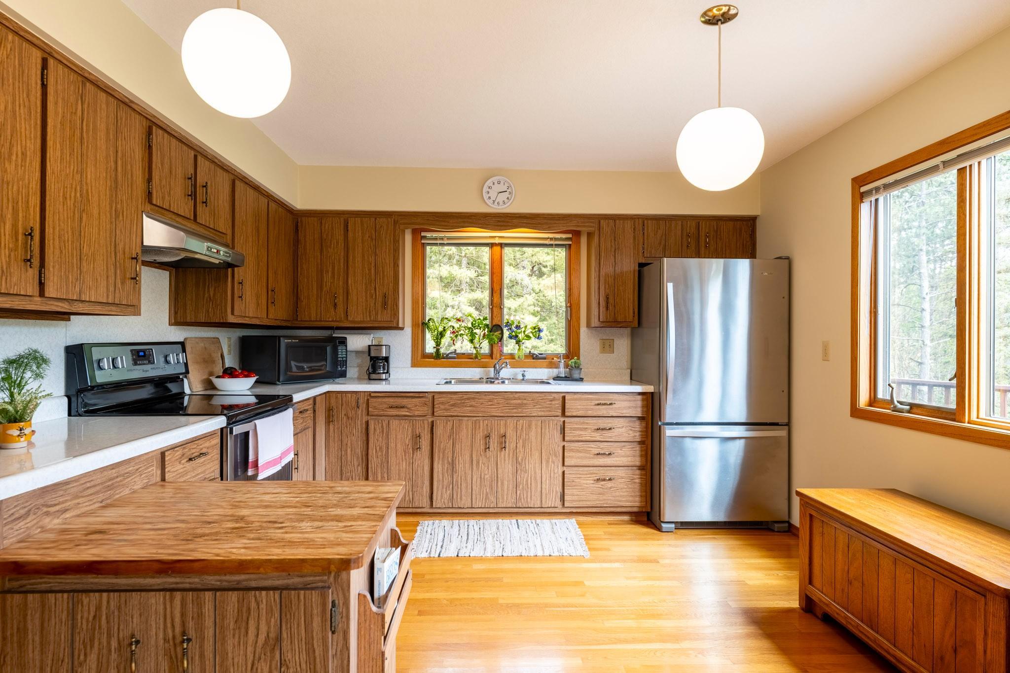 This spacious kitchen has room for a table and chairs under the large window.