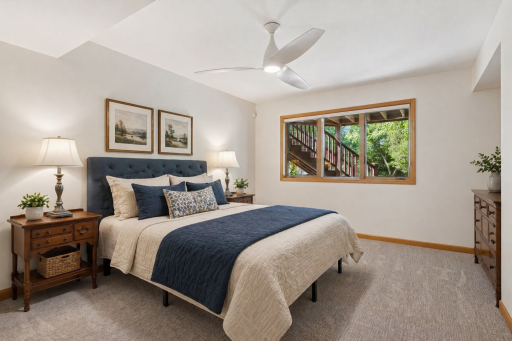 Spacious lower-level bedroom with large window, neutral finishes, and comfortable layout.This photo has been virtually staged.
