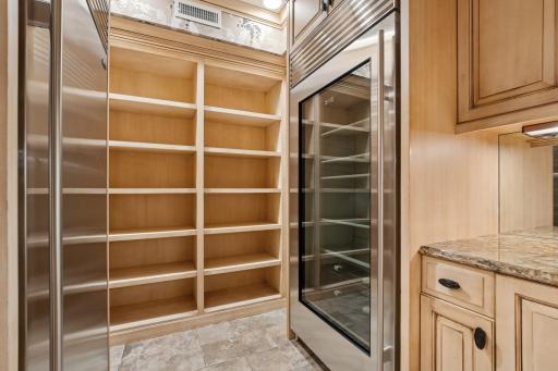 Butlerâs pantry with extensive cabinetry, granite surfaces, and premium Thermador and Sub-Zero appliances.