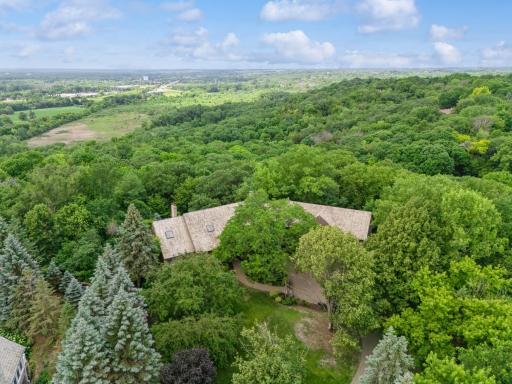 Aerial view showcasing the propertyâs wooded setting, rolling landscape views, and exceptional privacy.
