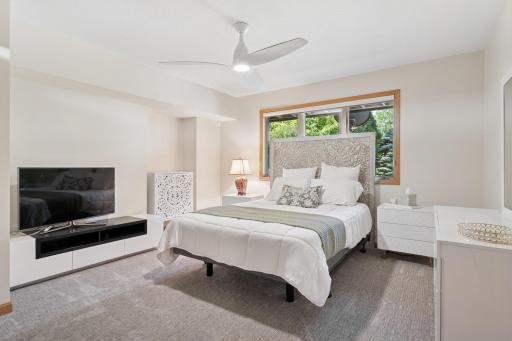 Spacious lower-level bedroom with large window, neutral finishes, and comfortable layout.