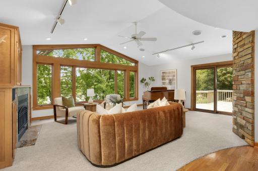 Another view of the vaulted lake room with custom built-ins, walls of windows, and the deck in the background.