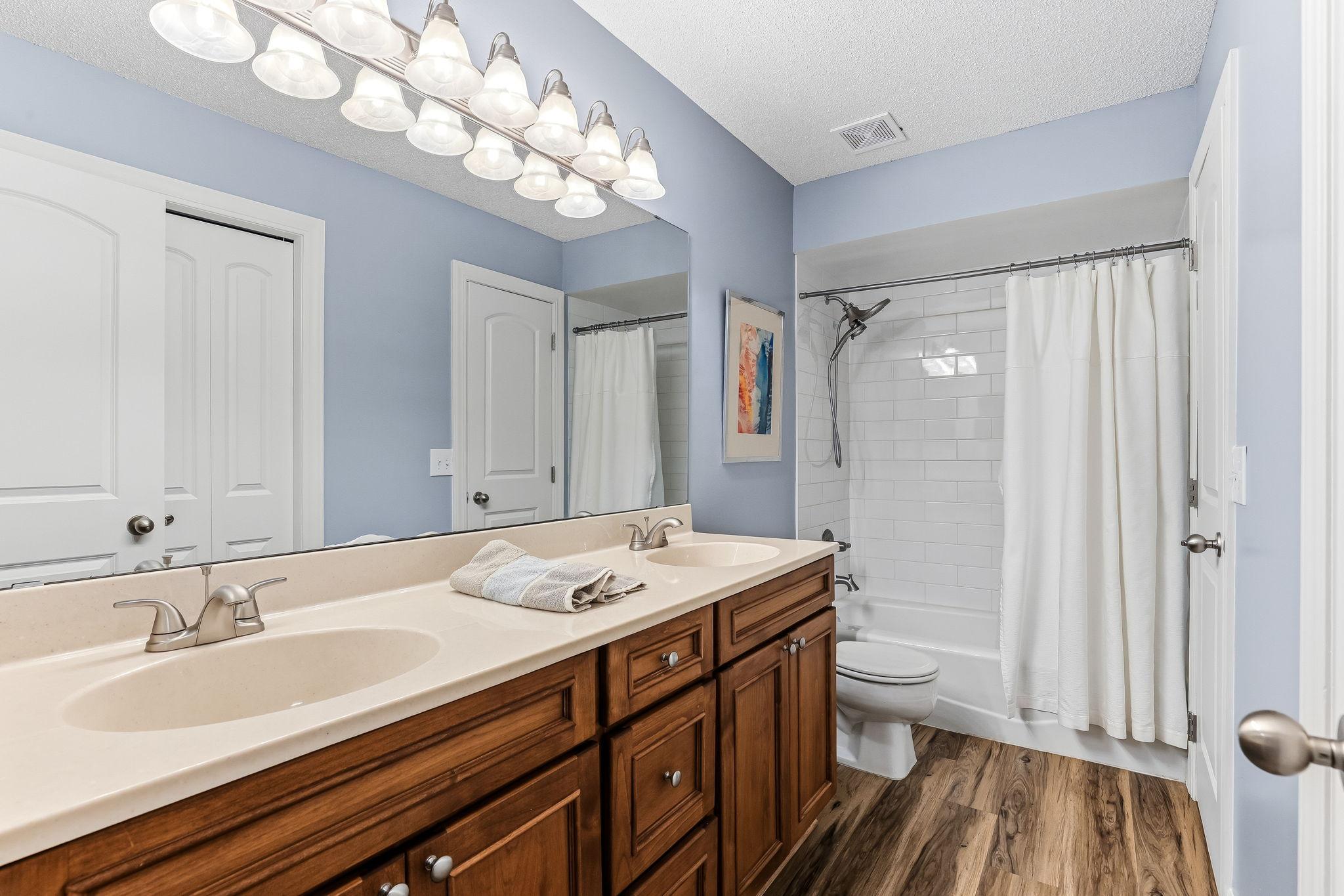 Spacious full bath with dual sinks and convenient access from the primary bedroom.