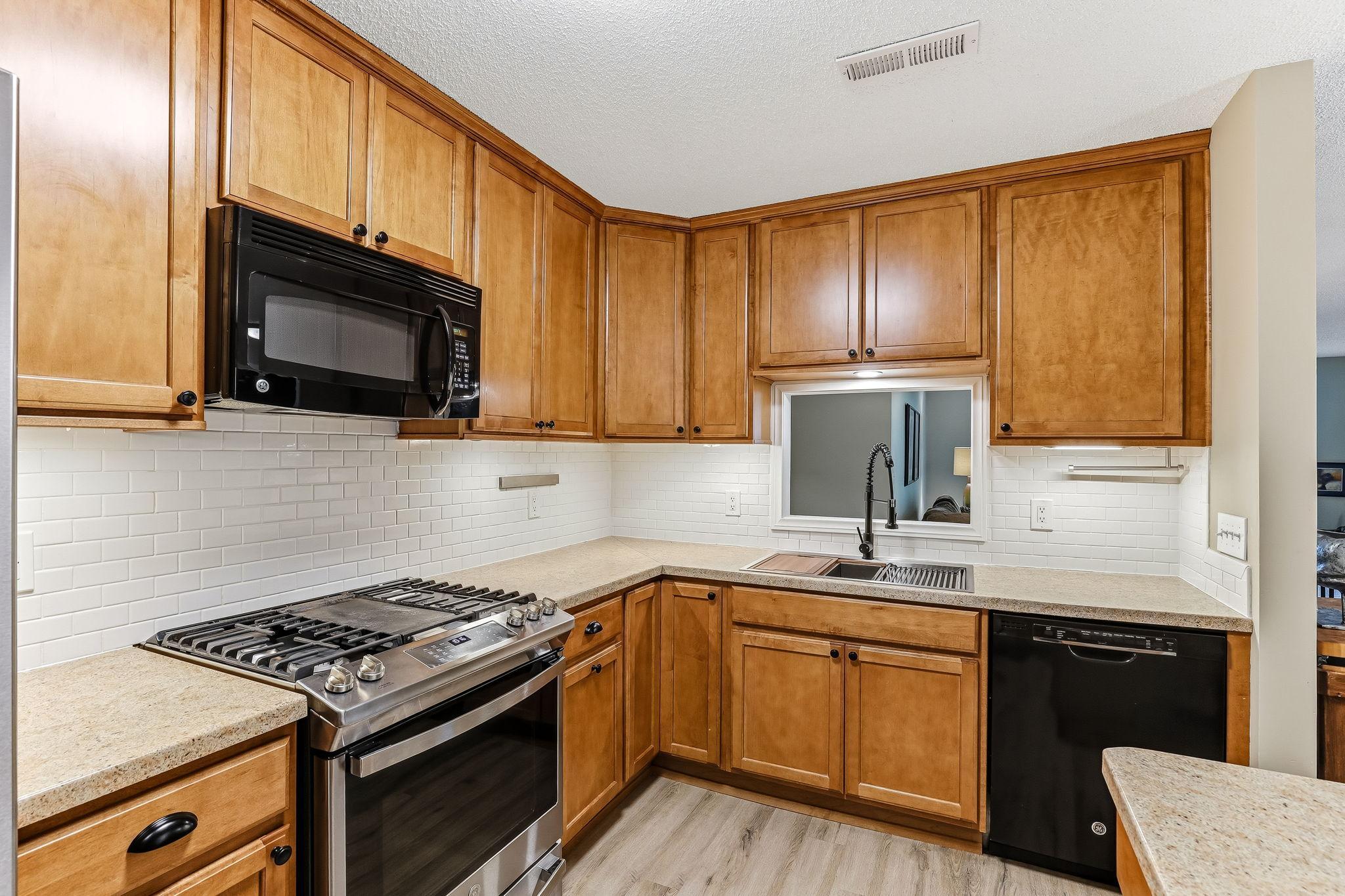 A kitchen pass-through window creates an open, connected feel between the kitchen and living room, offering convenient serving space and enhancing natural light and flow throughout the home.