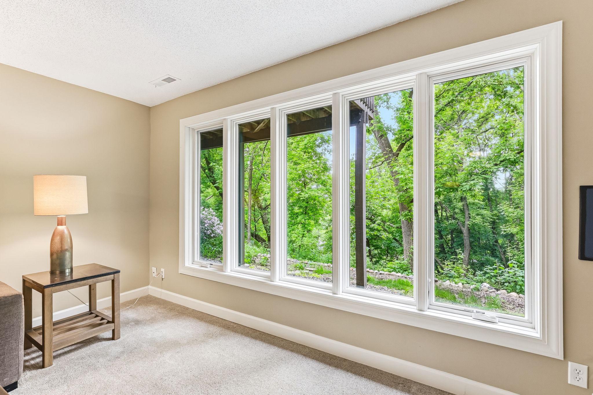 The massive window creates a seamless connection to the outdoors, offering year-round scenery.