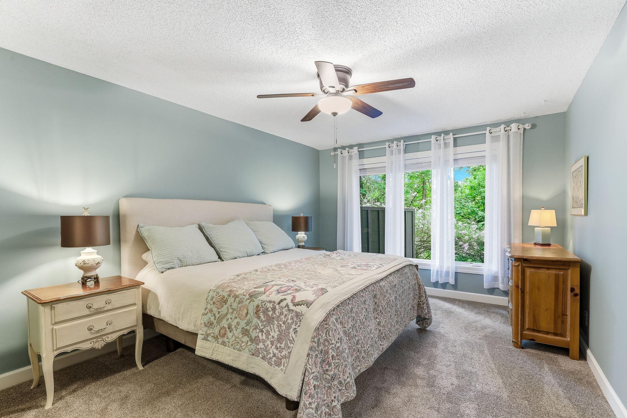 Bright primary bedroom featuring a huge window that fills the space with natural light.