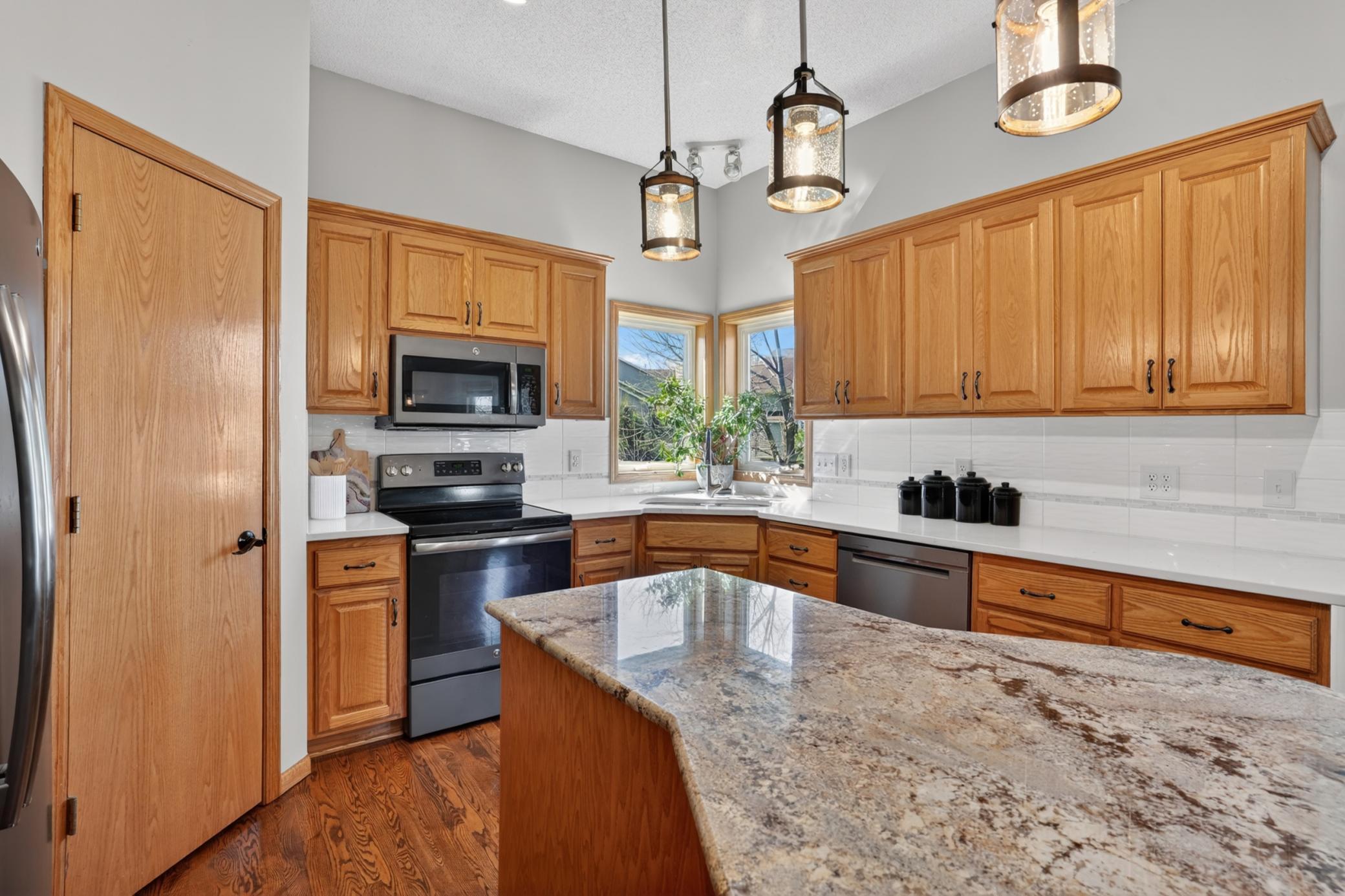 Updated kitchen with designer backsplash, hardwood floors, and abundant cabinet space