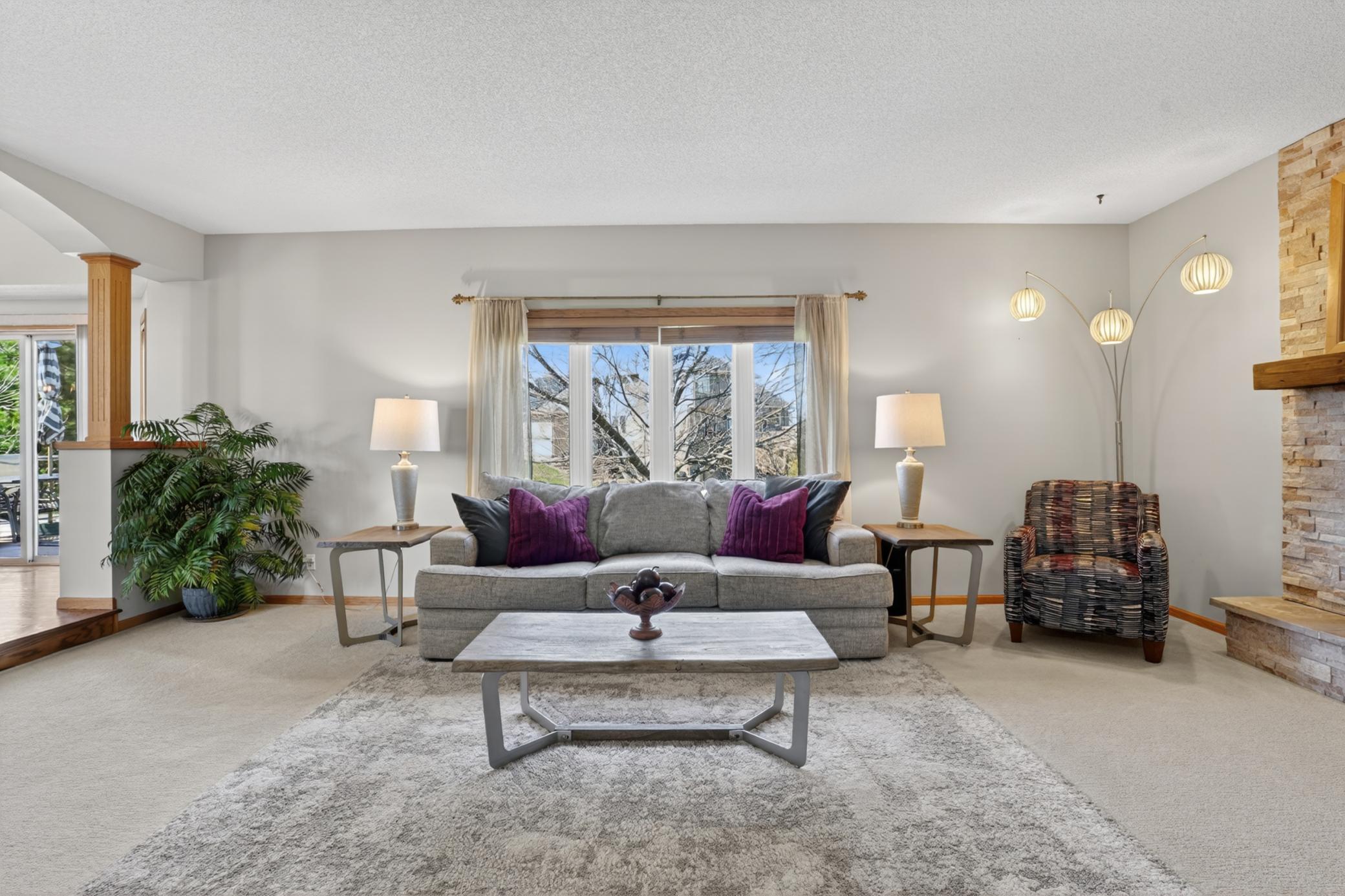 Main-level family room with large windows and updated designer fireplace focal wall