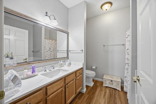 Even the bathroom is gorgeous! Note the pretty luxury plank wood floors and vanity top! The toilet was updated too!
