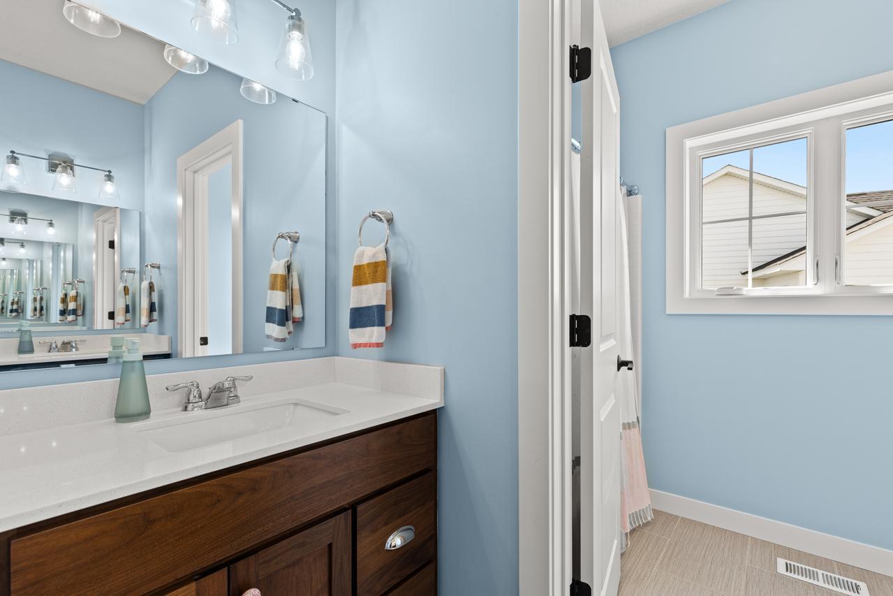 Upper Level Bathroom with a door dividing the vanity from the tub, and toilet.