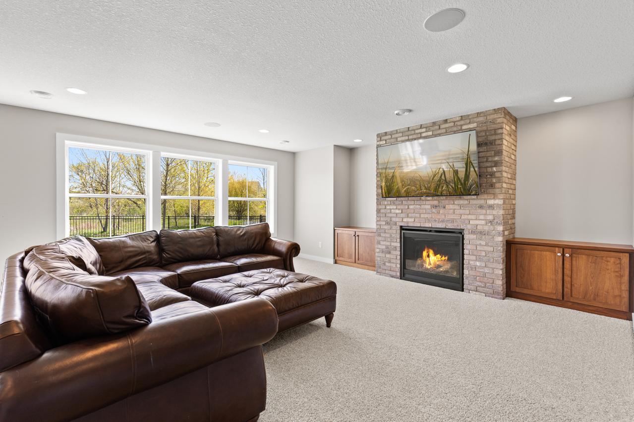 Lower-level family room with a gas fireplace and built-ins.