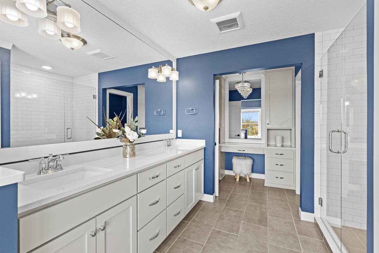 Double vanity sinks plus a bonus vanity with more storage make up the primary bathroom.