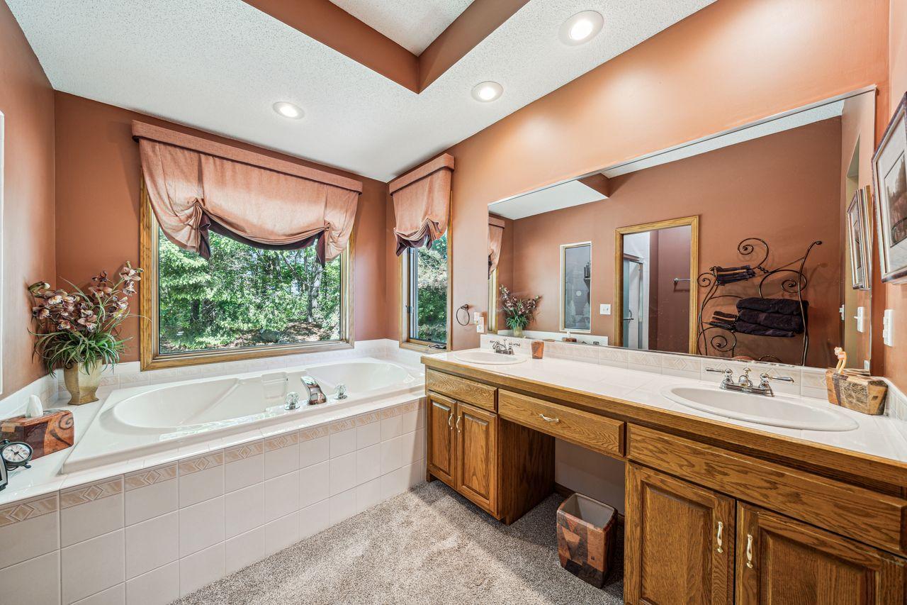 Double vanity, soaker tub, separate updated shower and walk in closet are featured in this en-suite bathroom