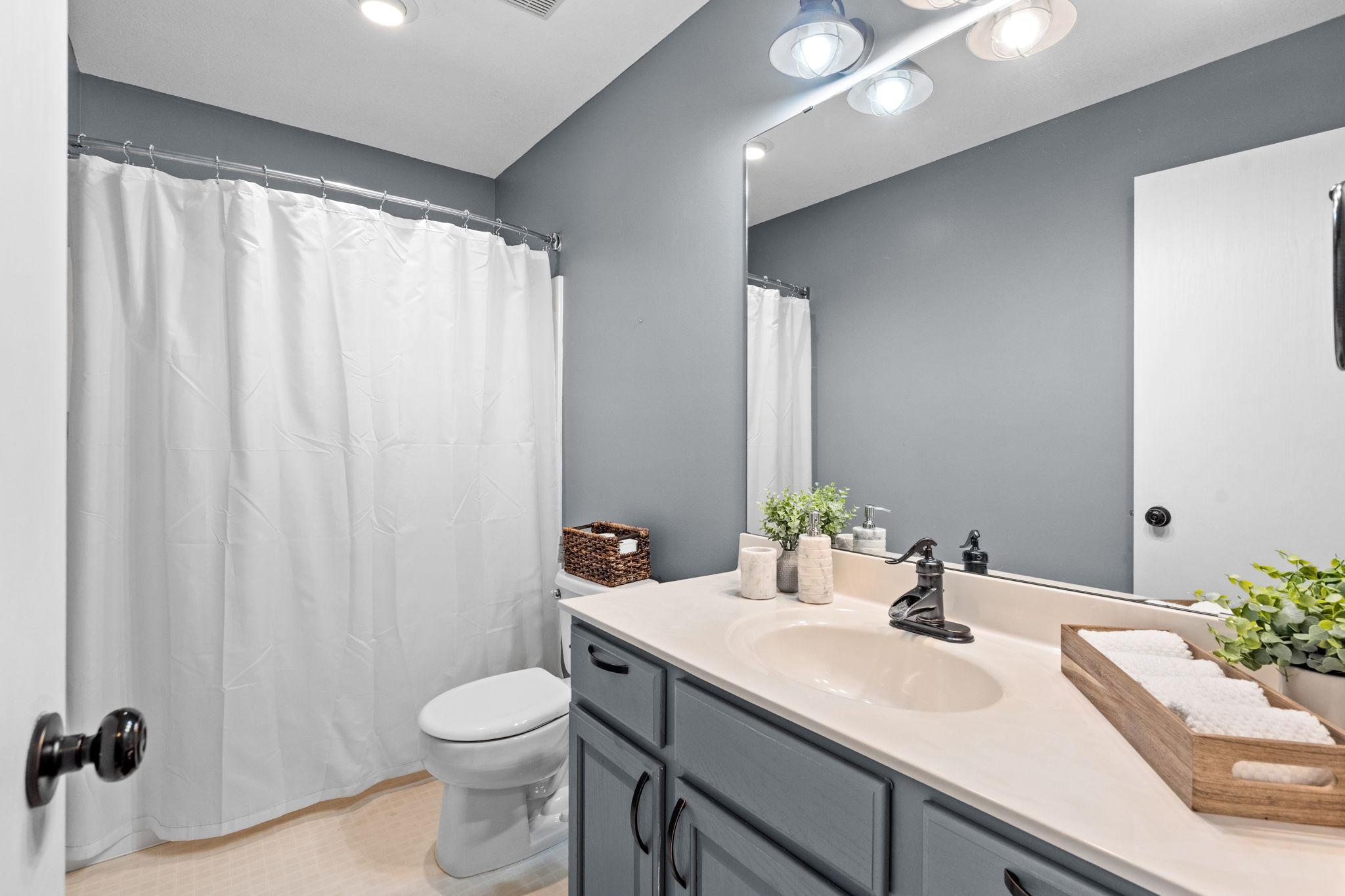 Upper-level full bath with clean finishes, functional layout, and everyday convenience for family or guests.