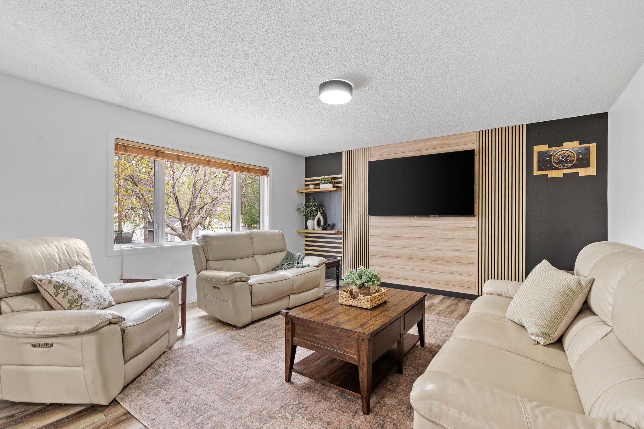 Large windows and open sightlines make this living room feel bright, airy, and connected to the rest of the home.