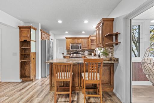 Spacious peninsula seating, warm wood finishes, and bright natural light make this kitchen feel both inviting and functional.