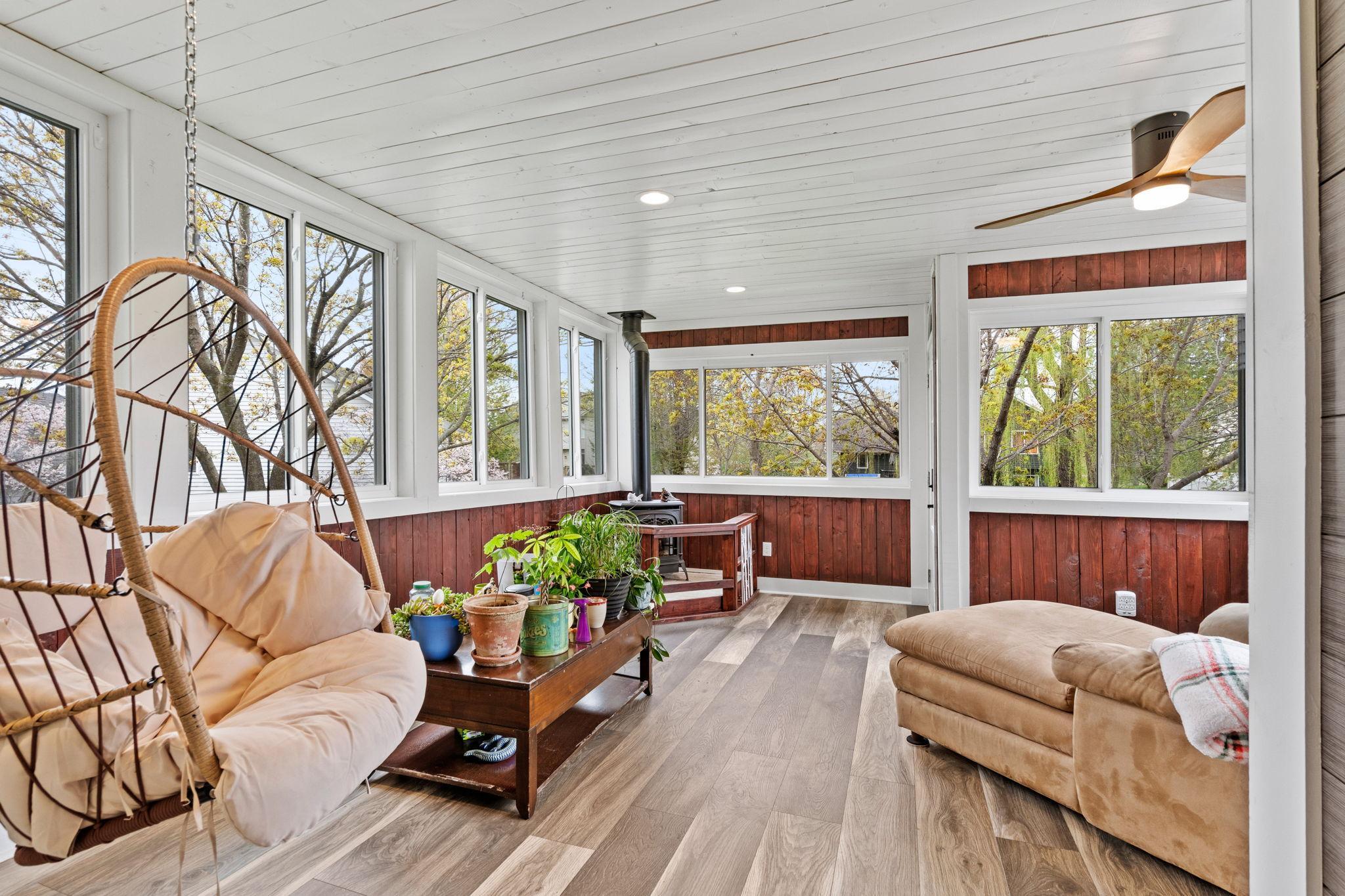 Stunning four-season porch surrounded by windows, creating the perfect space to relax and enjoy the view year-round.