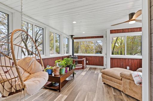 Stunning four-season porch surrounded by windows, creating the perfect space to relax and enjoy the view year-round.