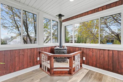 Cozy up by the freestanding stove while enjoying peaceful backyard views from this light-filled four-season retreat.