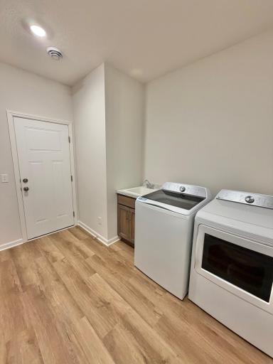 Photo of actual home. Top load washer and electric dryer by GE are included, along with a laundry sink with cabinet!