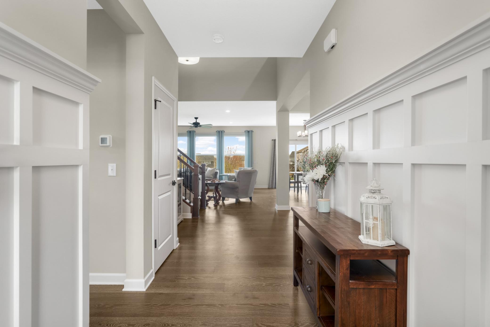 The foyer greets you upon entrance. Note the decorative wainscotting and beautiful hardwood floors throughout!
