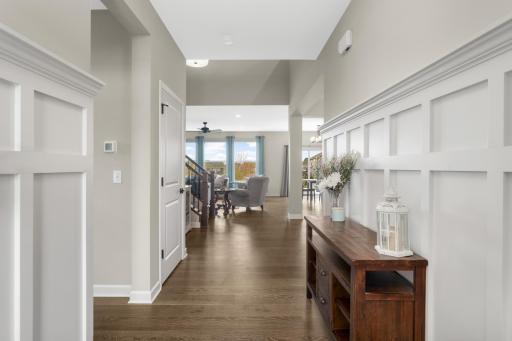 The foyer greets you upon entrance. Note the decorative wainscotting and beautiful hardwood floors throughout!