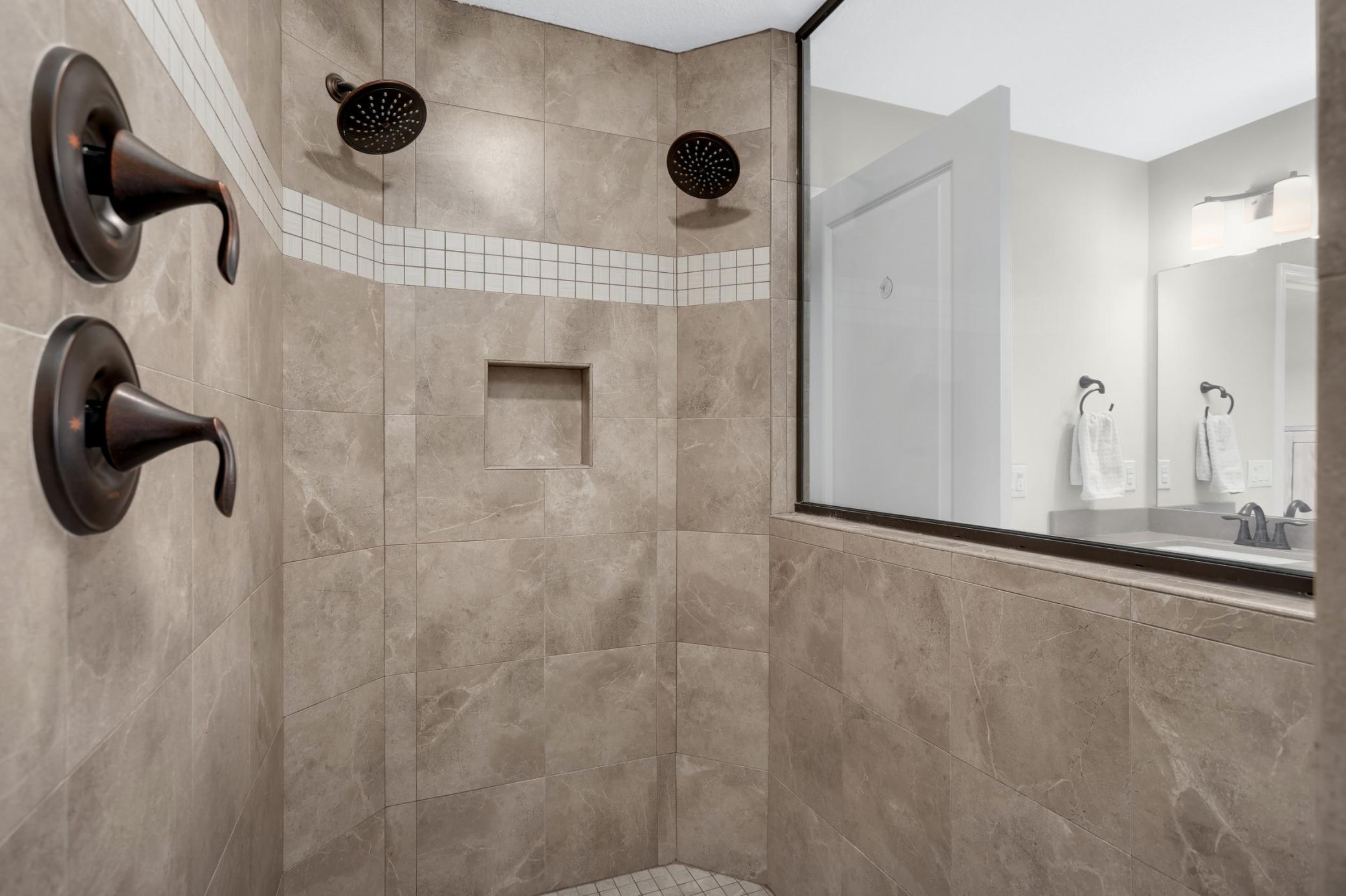 Walk-in shower with dual shower heads.