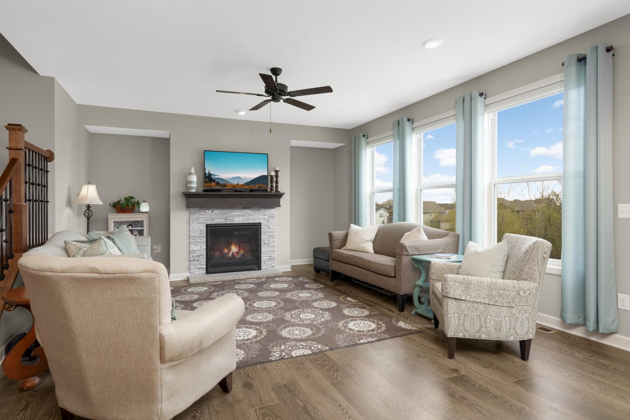 The living room features large windows providing ample natural light throughout.