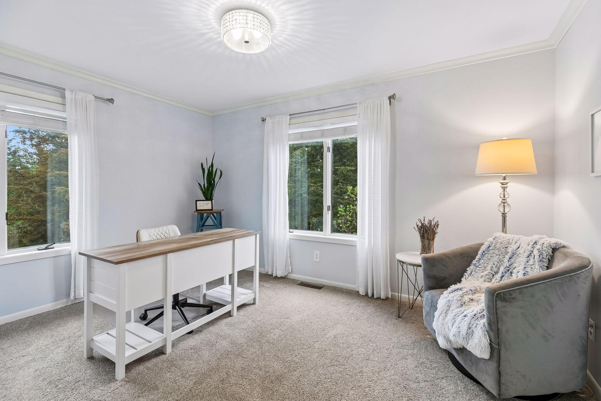 Versatile second main level bedroom currently set up as an office, with carpet flooring, overhead lighting, and four windows enhancing the space.