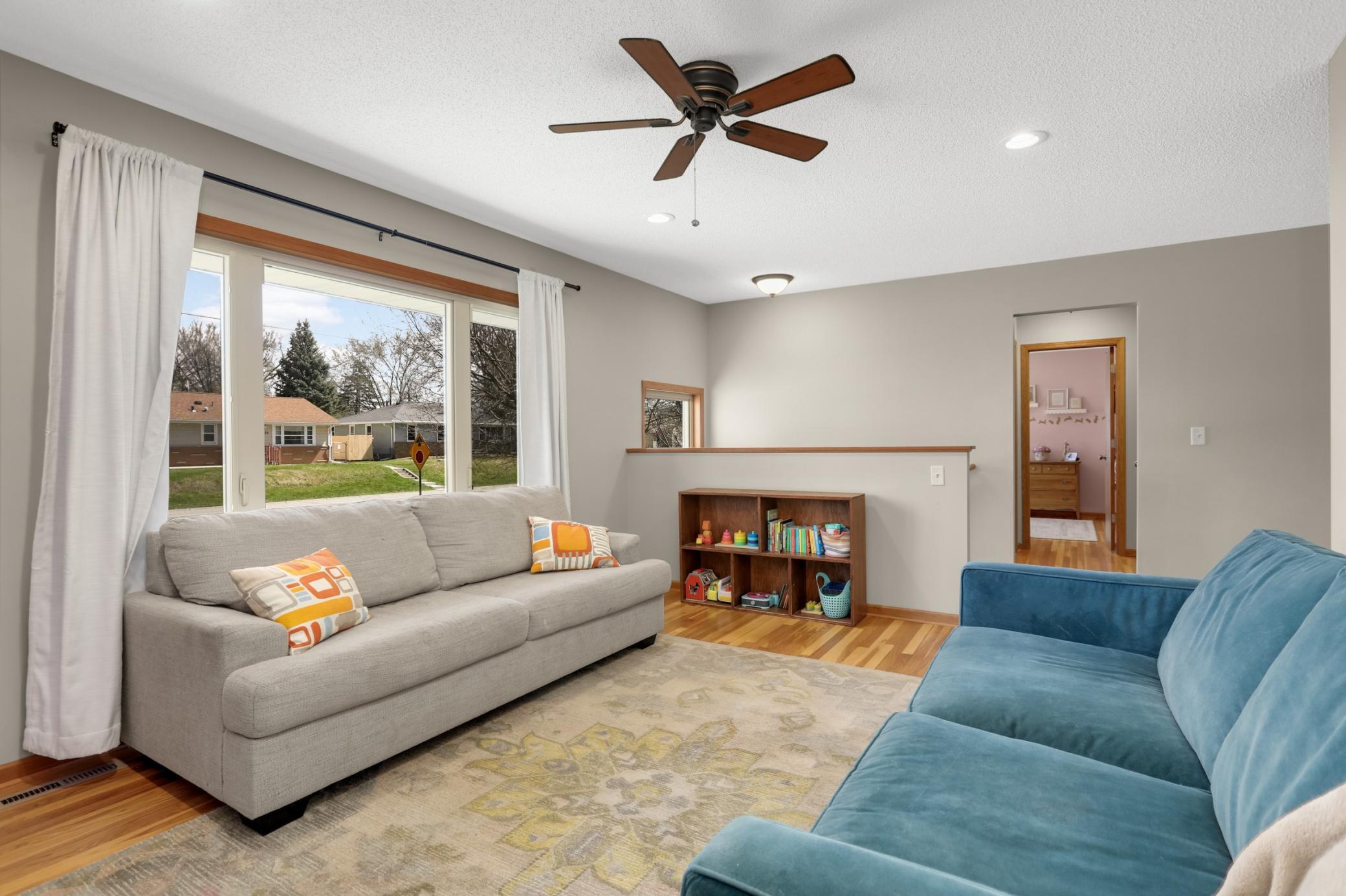 Bright Living Room with hard wood floors and ceiling fan.