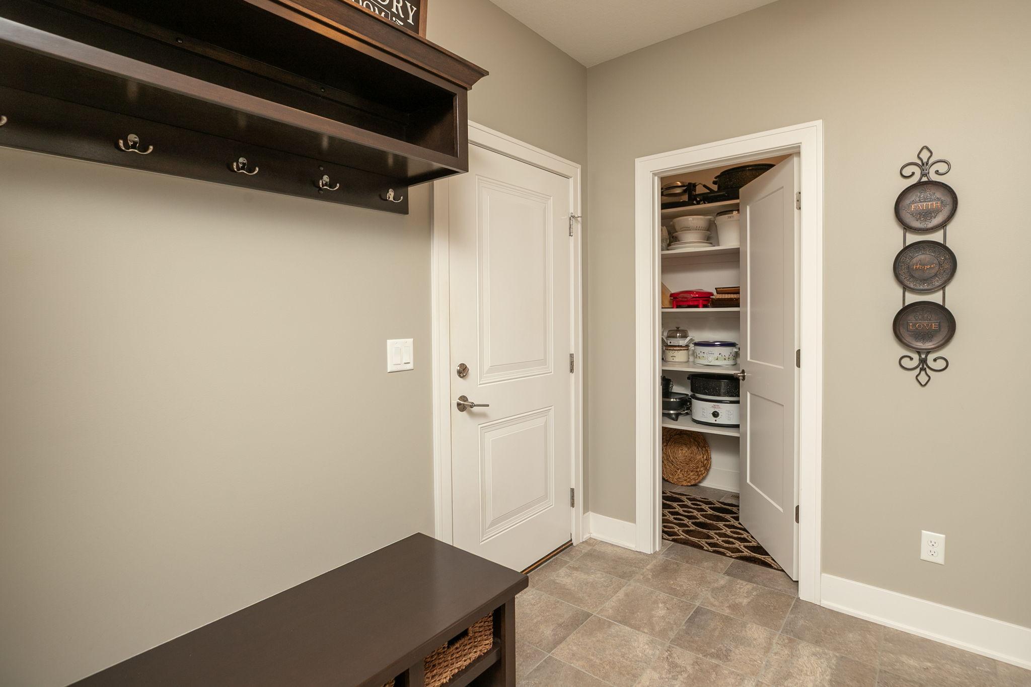 Mudroom with bench and large closet ,which is also useful for the pantry items