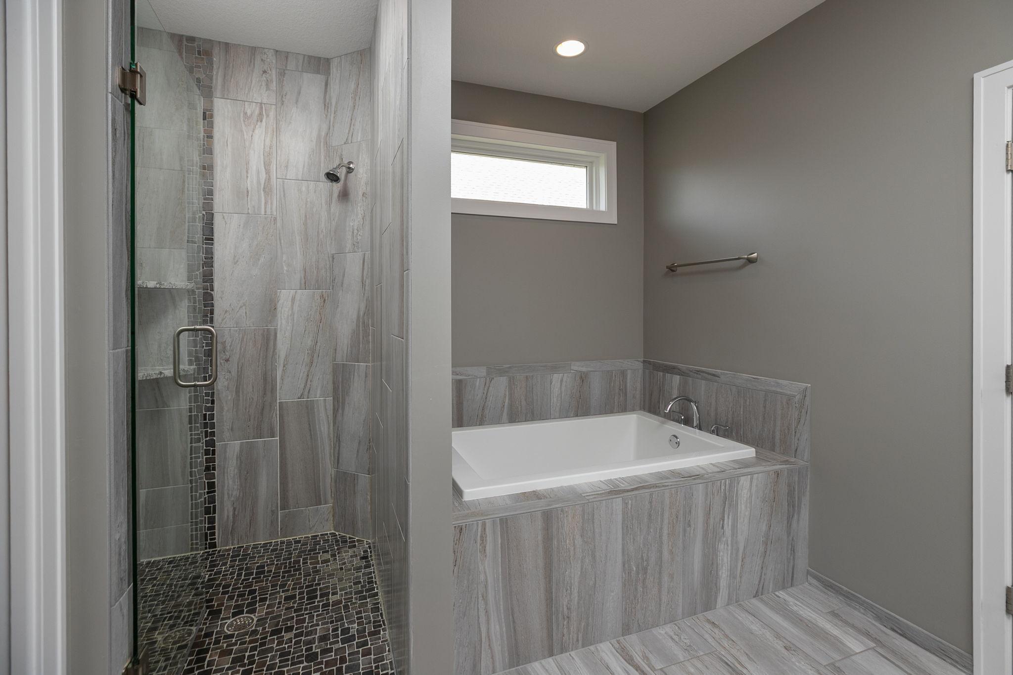 Separate tub and walk-in tiled shower w/ glass door