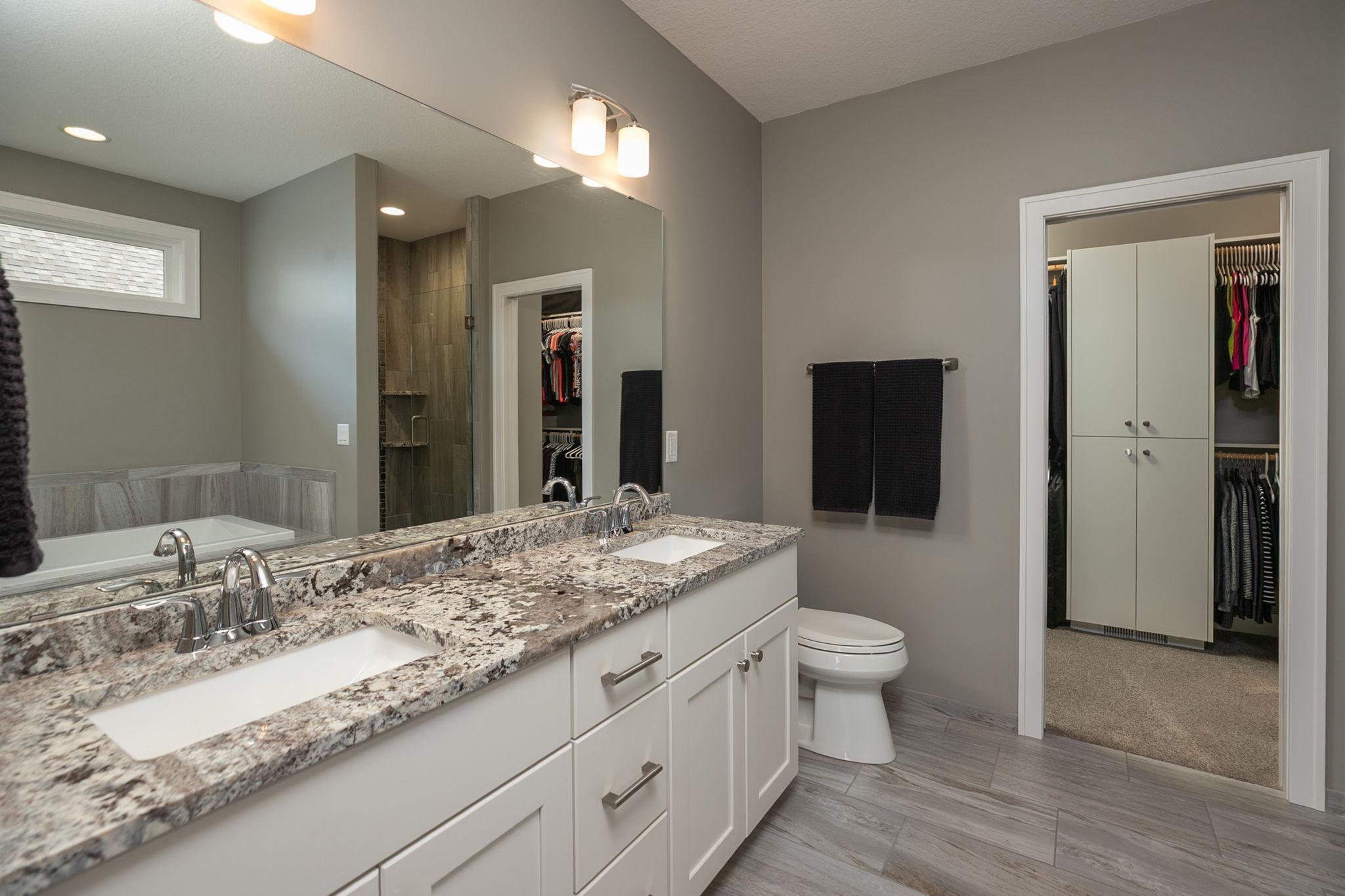 Double sinks, granite tops and full width mirror in primary bath