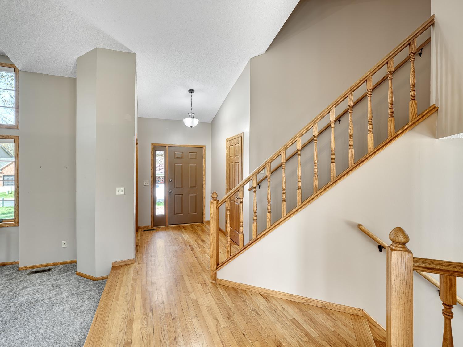 The impressive style of this home begins with neutral tones, soaring vaulted ceilings, and gleaming hardwood floors in the entry.