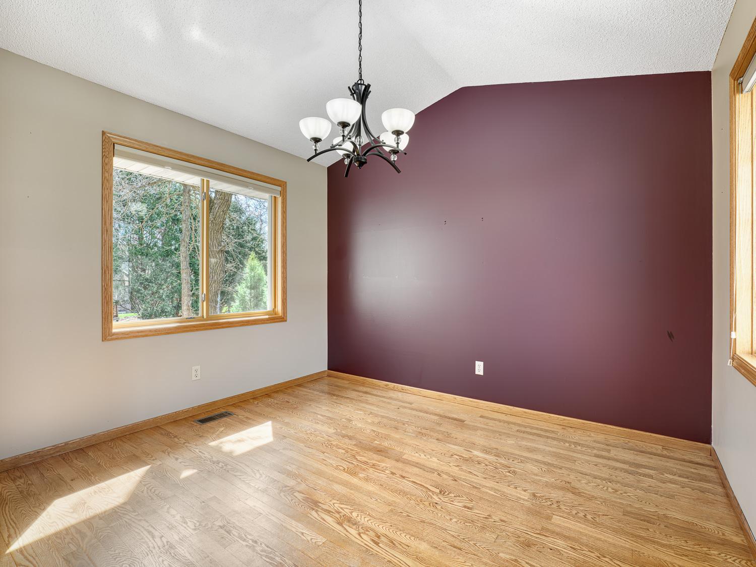The formal dining area is ideal for hosting and easily accommodates larger gatherings, featuring hardwood floors and dual windows that fill the space with natural light.