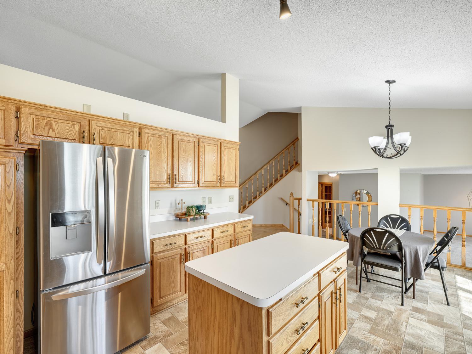 The kitchen features abundant wood cabinetry and a center island, offering plenty of prep and storage space.