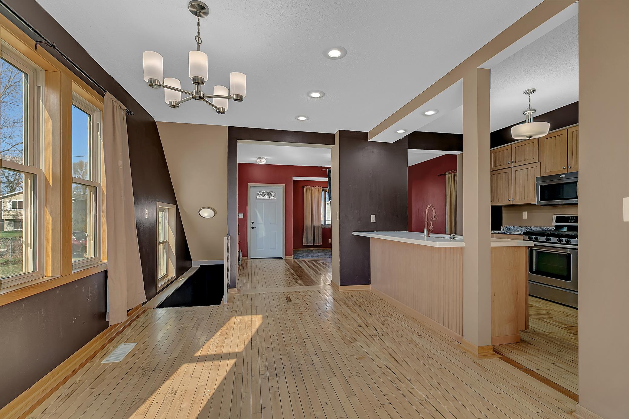 Spacious dining room with updated light fixture and recessed lighting.