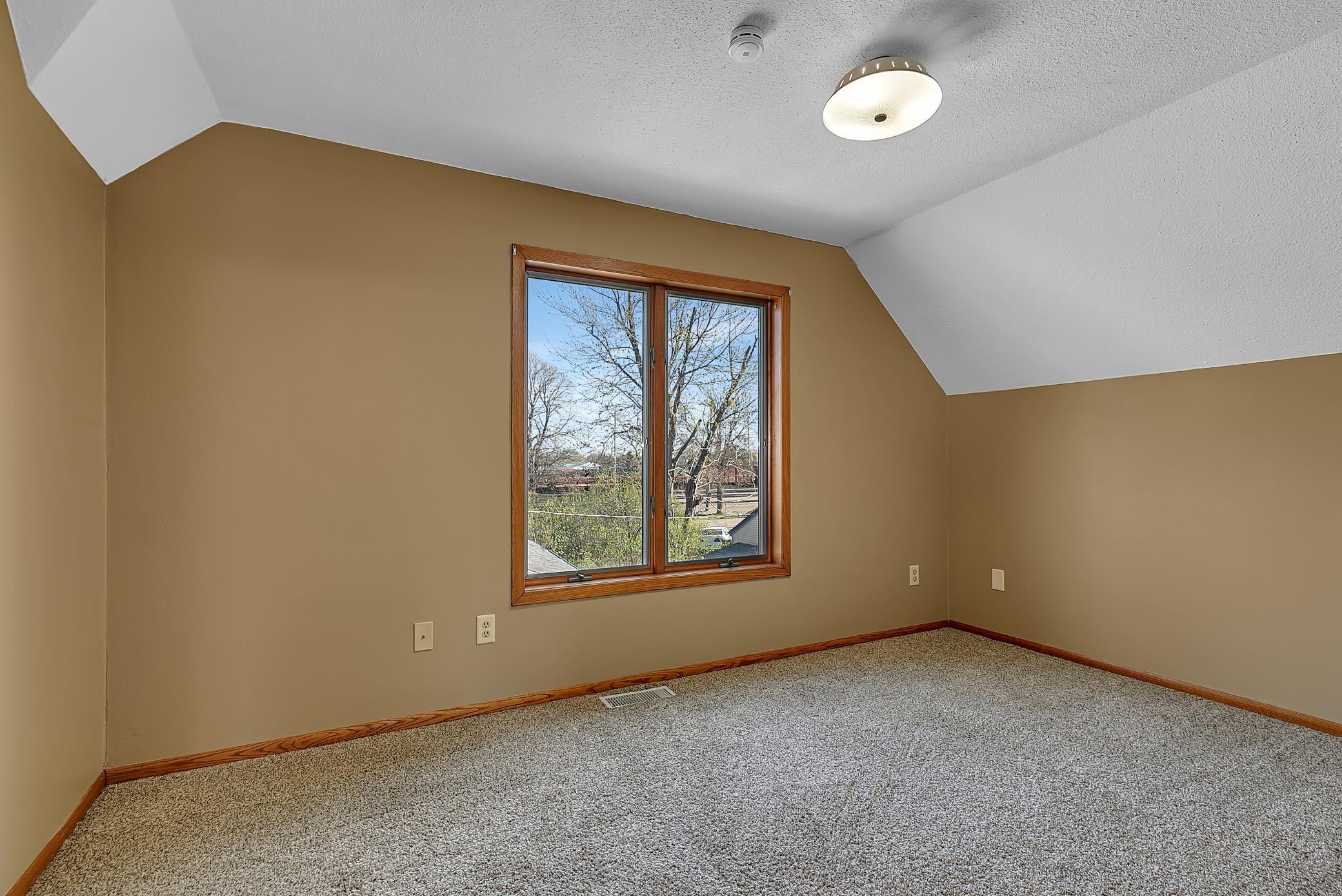 2nd upper level bedroom. In the hallway is a built-in linen closet with cabinets and drawers and across from it is a laundry chute.