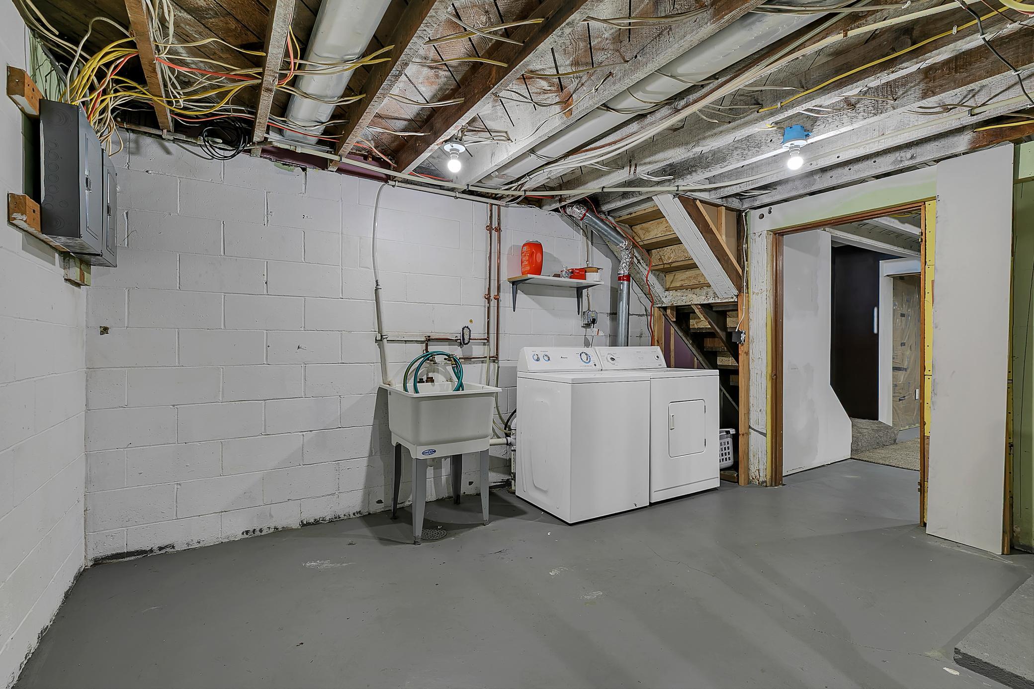 Spacious mechanical room that houses the washer, dryer and utility sink. The washer and dryer will stay with the home.
