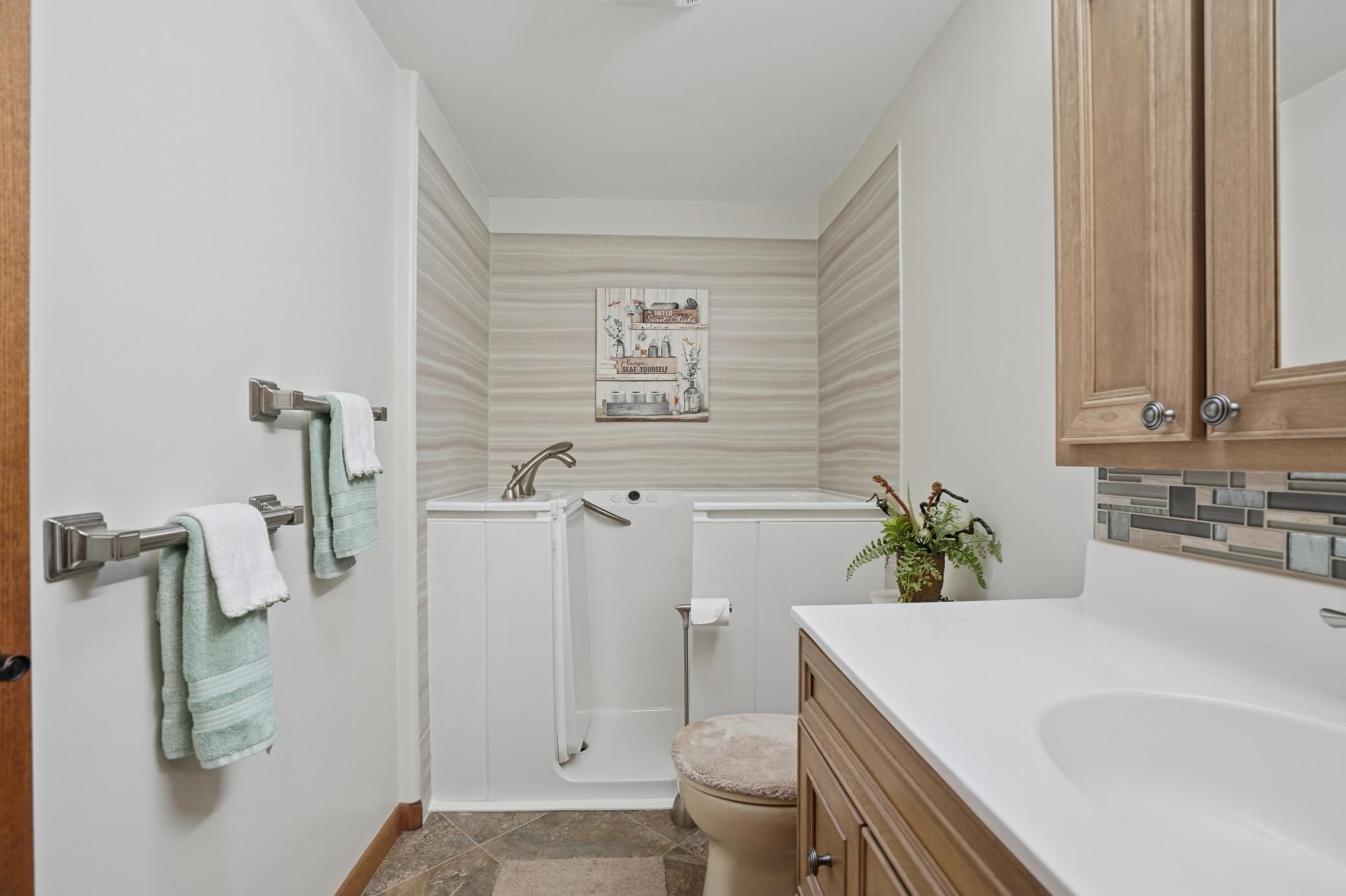 The second full bathroom on the main floor features a walk-in tub with grab bars.