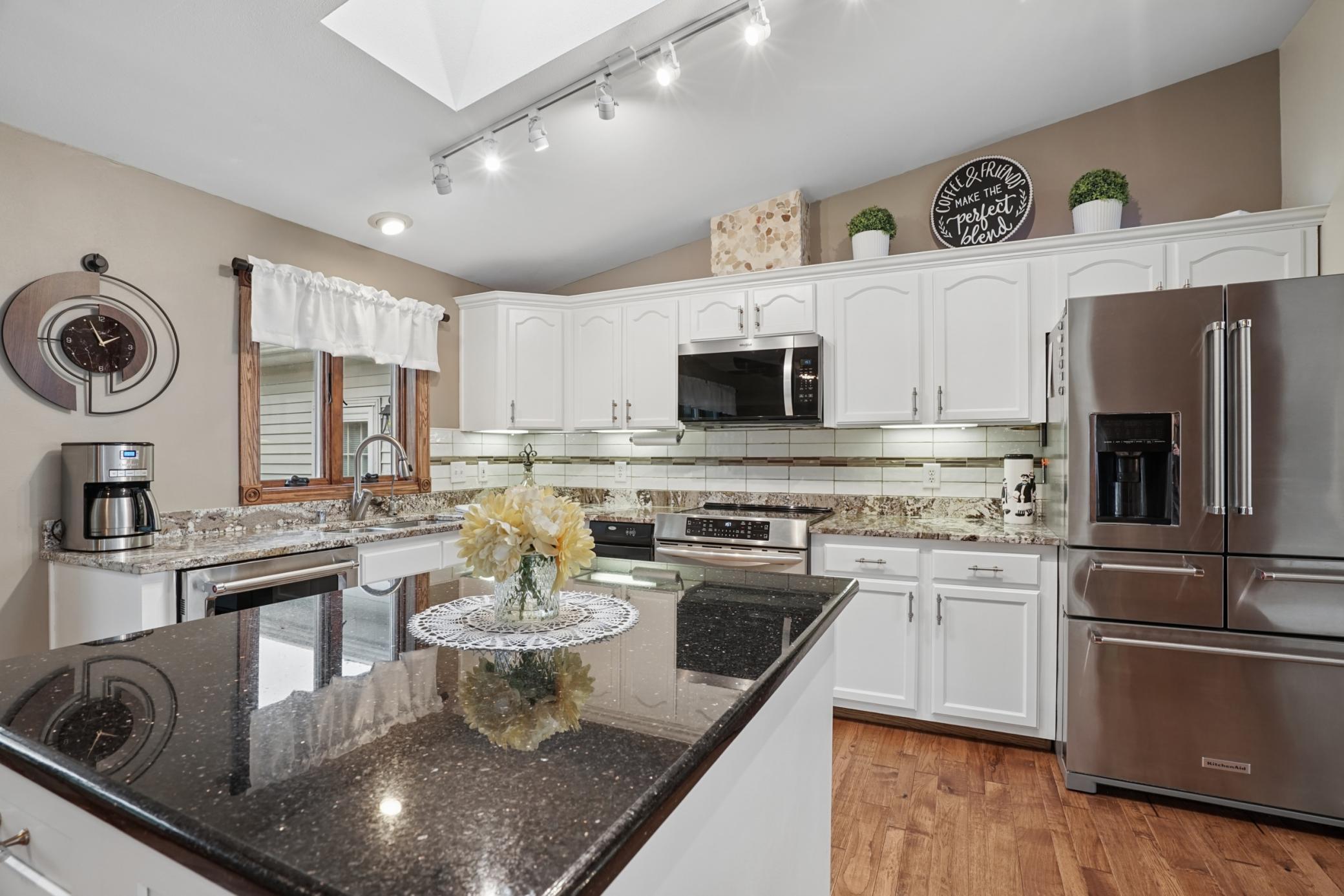 The kitchen features S.S. appliances, a window over the sink, and a trash compactor.