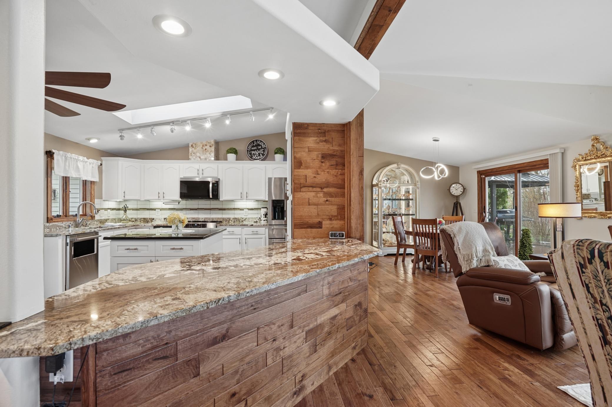 The gourmet kitchen is a chef's dream, bathed in natural light from a skylight. Features include S.S. appliances, granite countertops, and a pantry.
