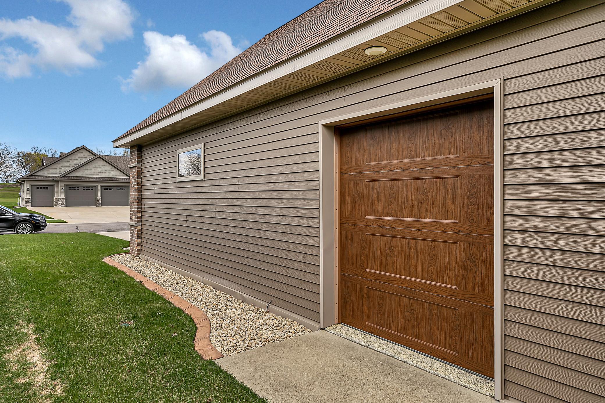 The side overhead door is perfect for a lawn mower or golf cart. A service door and concrete driveway add everyday convenience.